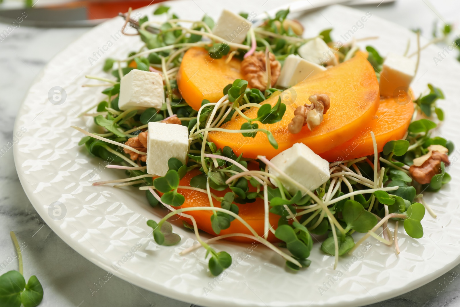 Photo of Delicious persimmon salad served on table, closeup
