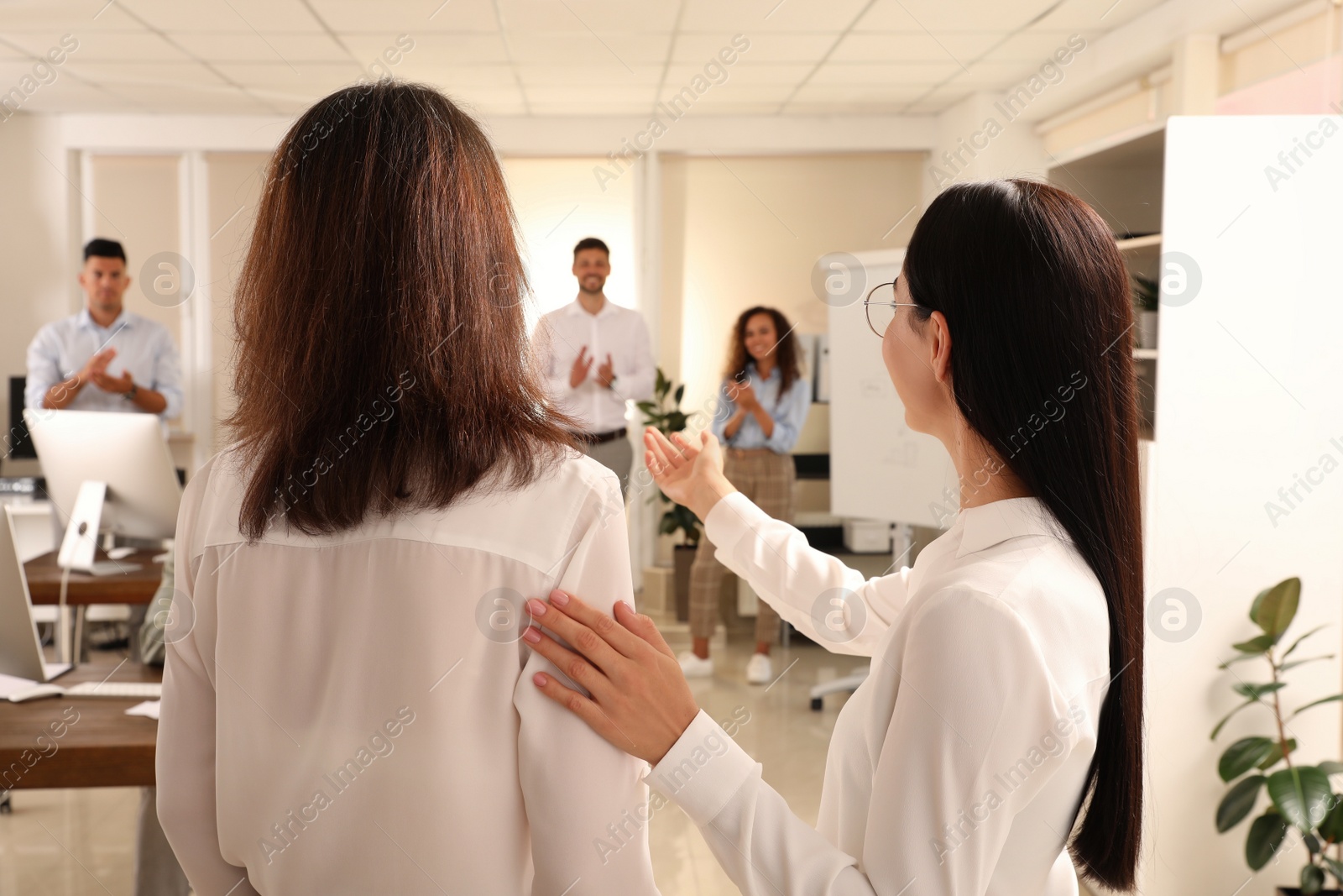 Photo of Boss introducing new employee to coworkers in office