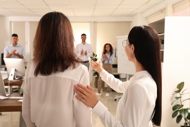 Photo of Boss introducing new employee to coworkers in office