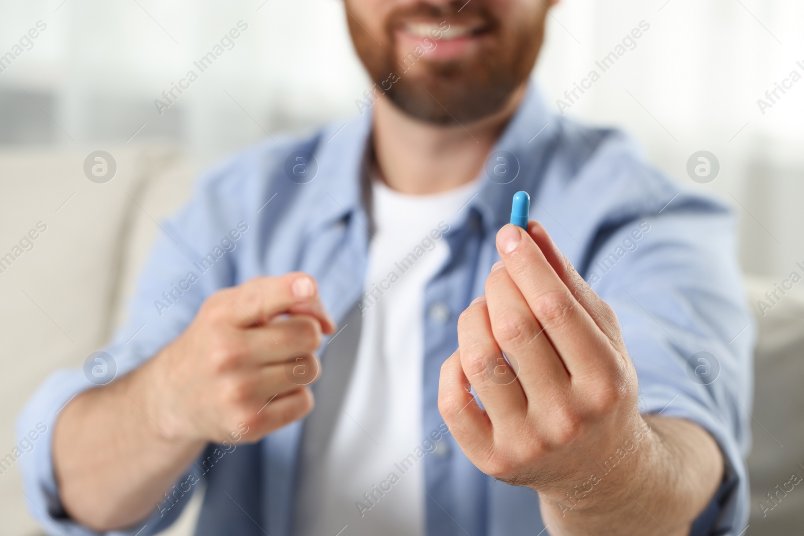Photo of Man showing pill indoors, closeup. Space for text