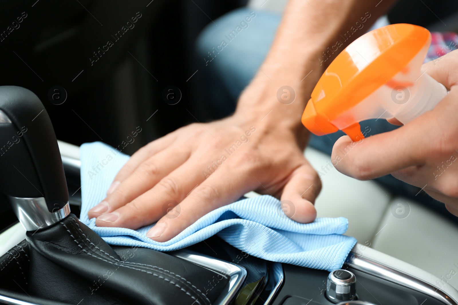 Photo of Man washing car salon with rag, closeup