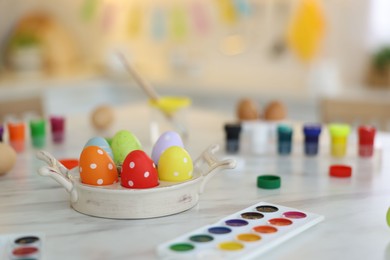 Happy Easter. Painted eggs and watercolor on white marble table indoors