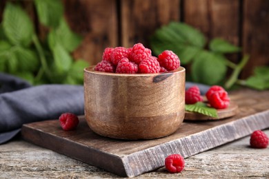Photo of Bowl of fresh red ripe raspberries on wooden table