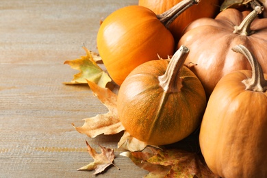 Photo of Ripe pumpkins on wooden background, space for text. Holiday decoration