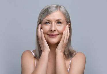 Photo of Portrait of beautiful senior woman on grey background