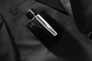 Luxury men's perfume in bottle on black jacket, top view