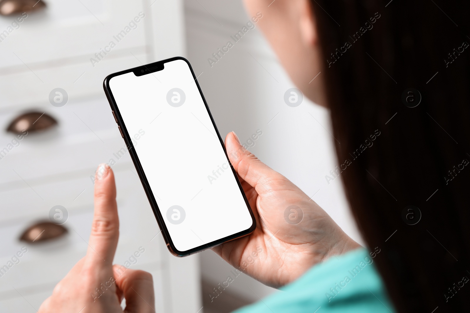 Photo of Woman holding smartphone with blank screen indoors, closeup. Mockup for design