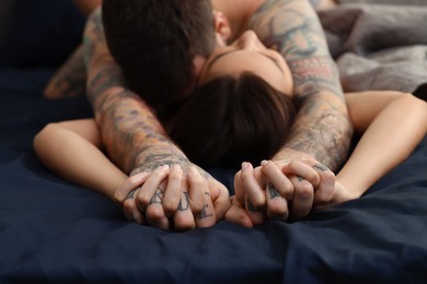 Passionate couple having sex on bed, focus on hands