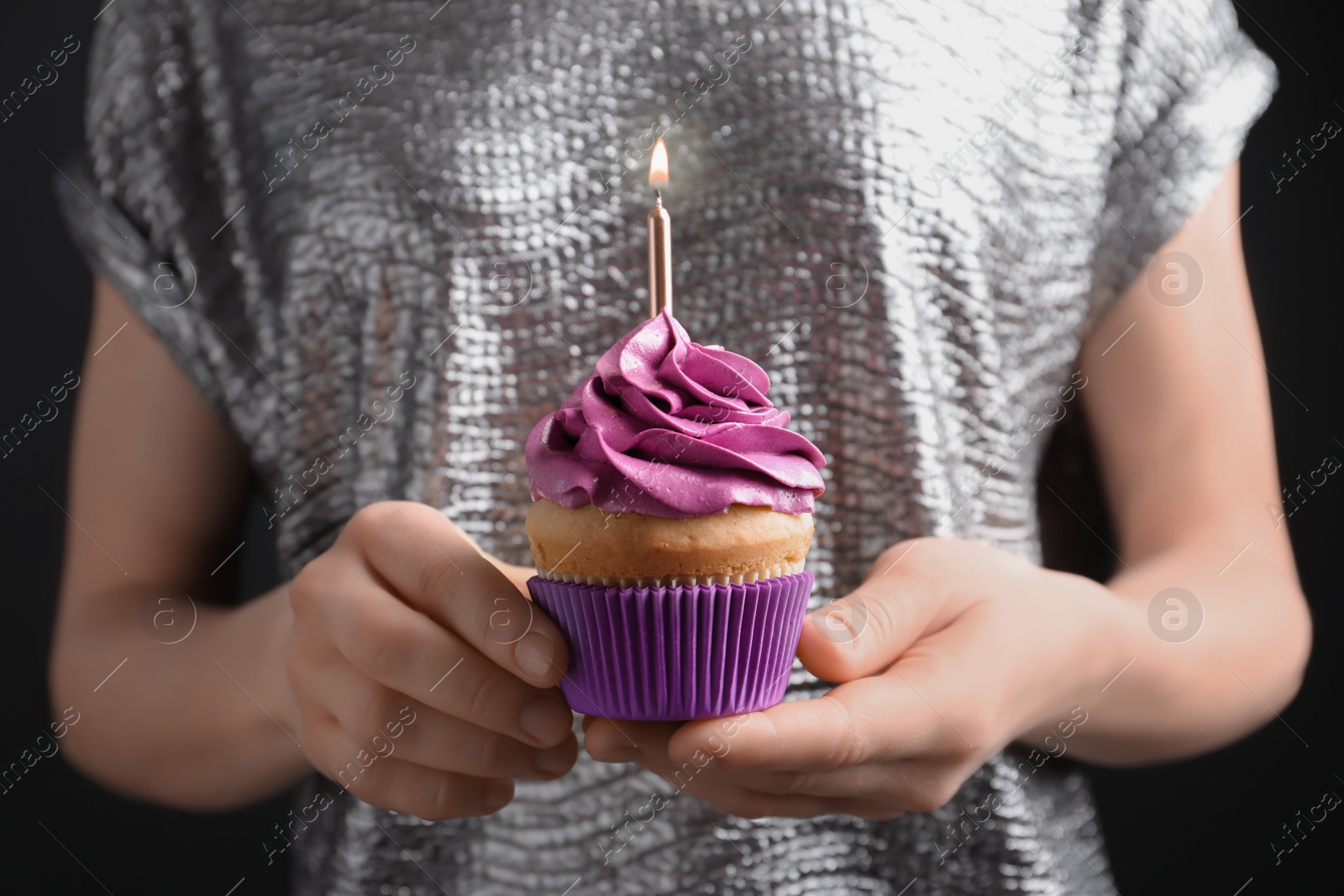 Photo of Woman holding birthday cupcake, closeup