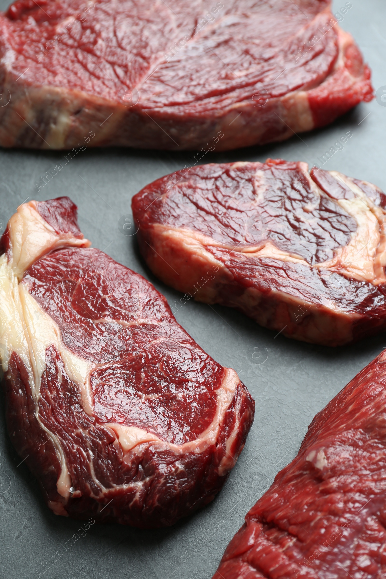 Photo of Pieces of raw beef meat on grey table