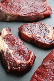 Photo of Pieces of raw beef meat on grey table