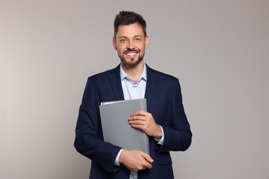 Photo of Happy teacher with stationery against beige background