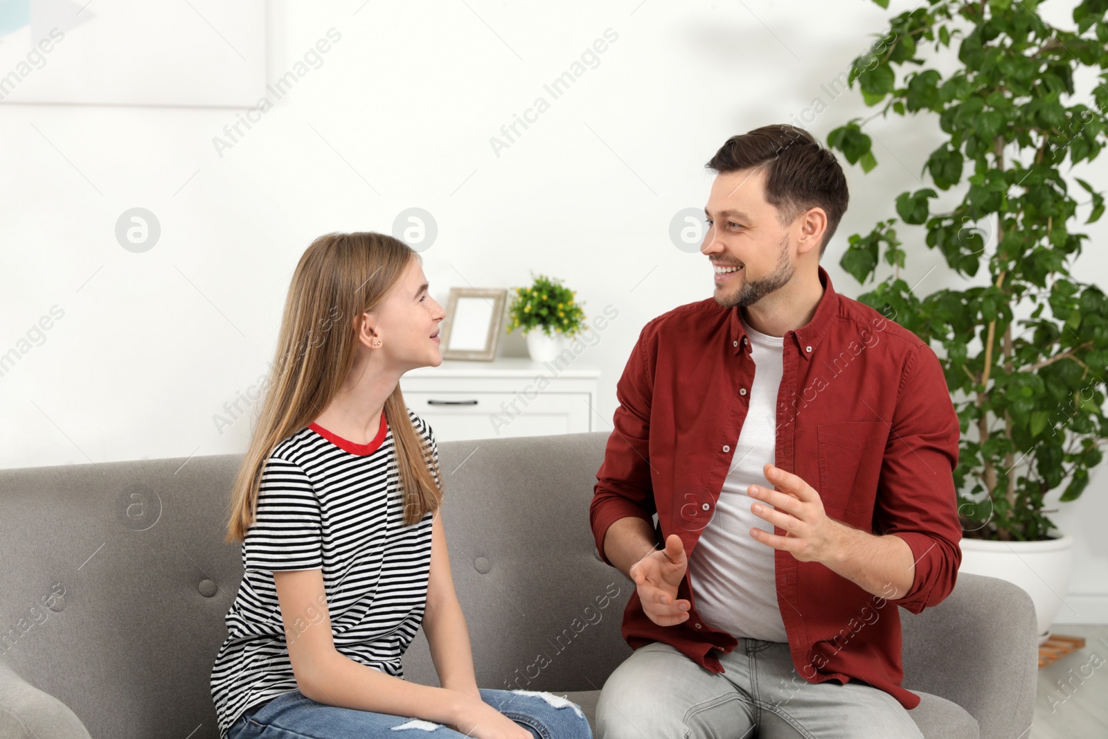 Photo of Father talking with his teenager daughter at home