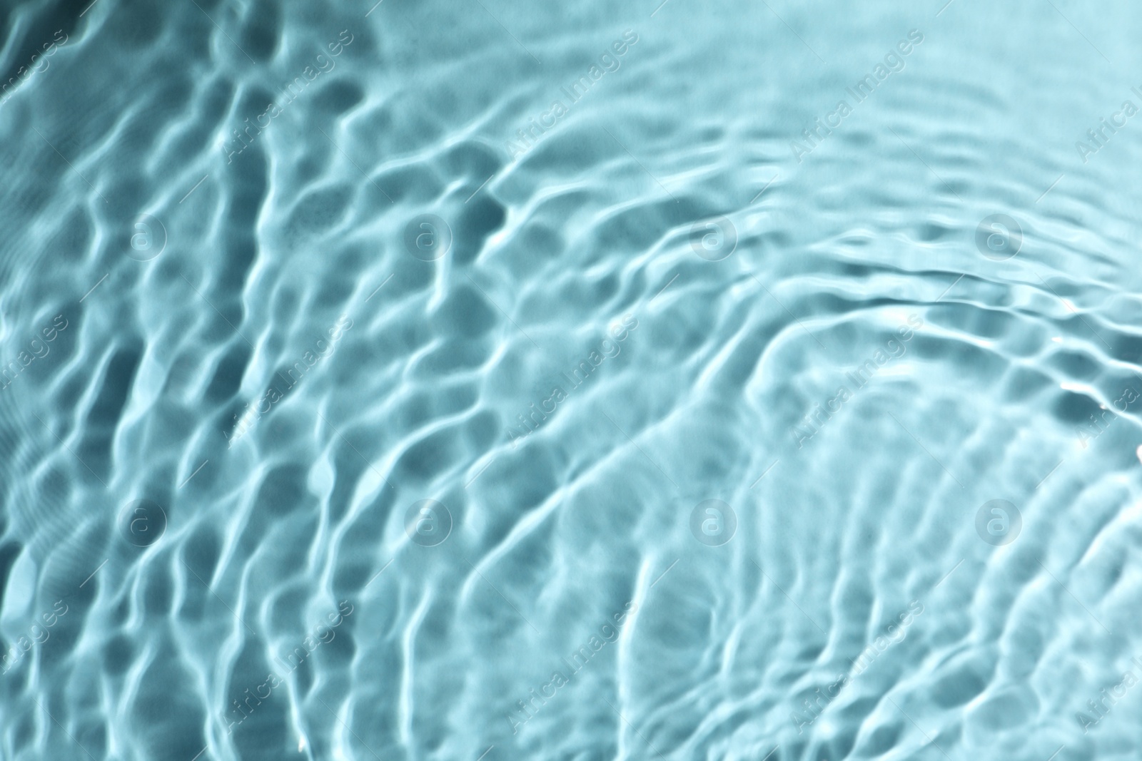 Photo of Closeup view of water with rippled surface on turquoise background