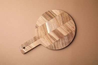 One wooden board on beige background, top view