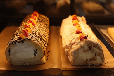 Delicious cake and meringue rolls on counter in bakery shop, closeup