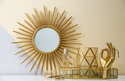 Photo of Composition with golden accessories and jewelry on dressing table near color wall