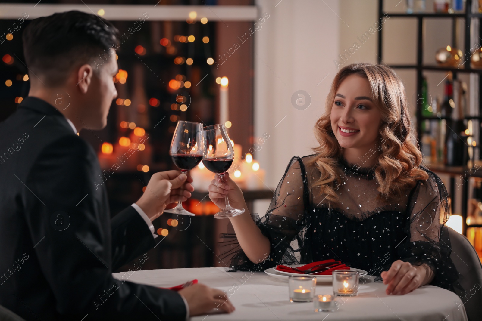 Photo of Lovely couple clinking glasses at Valentine's day dinner in restaurant