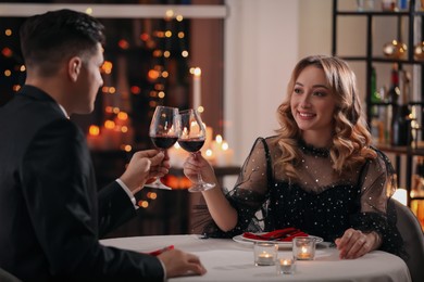 Photo of Lovely couple clinking glasses at Valentine's day dinner in restaurant