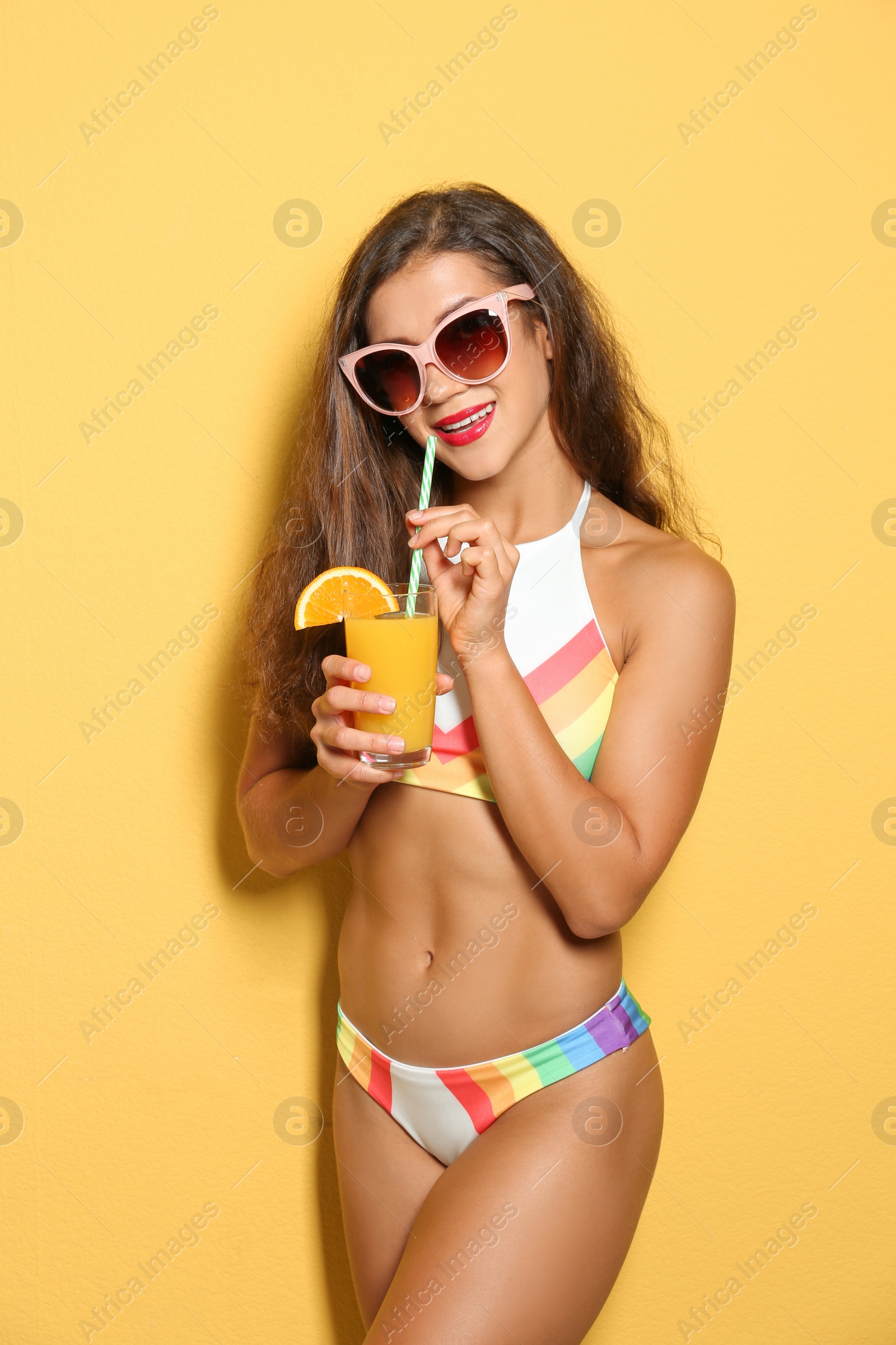 Photo of Beautiful young woman with inflatable ring and glass of cocktail on color background