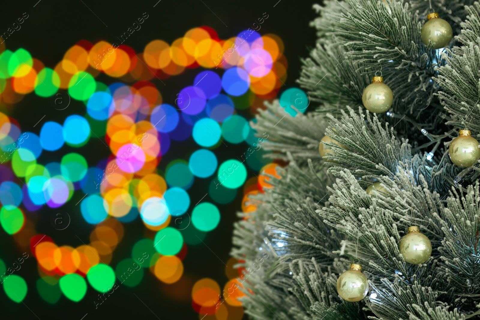 Photo of Decorated Christmas tree against blurred festive lights, closeup. Space for text