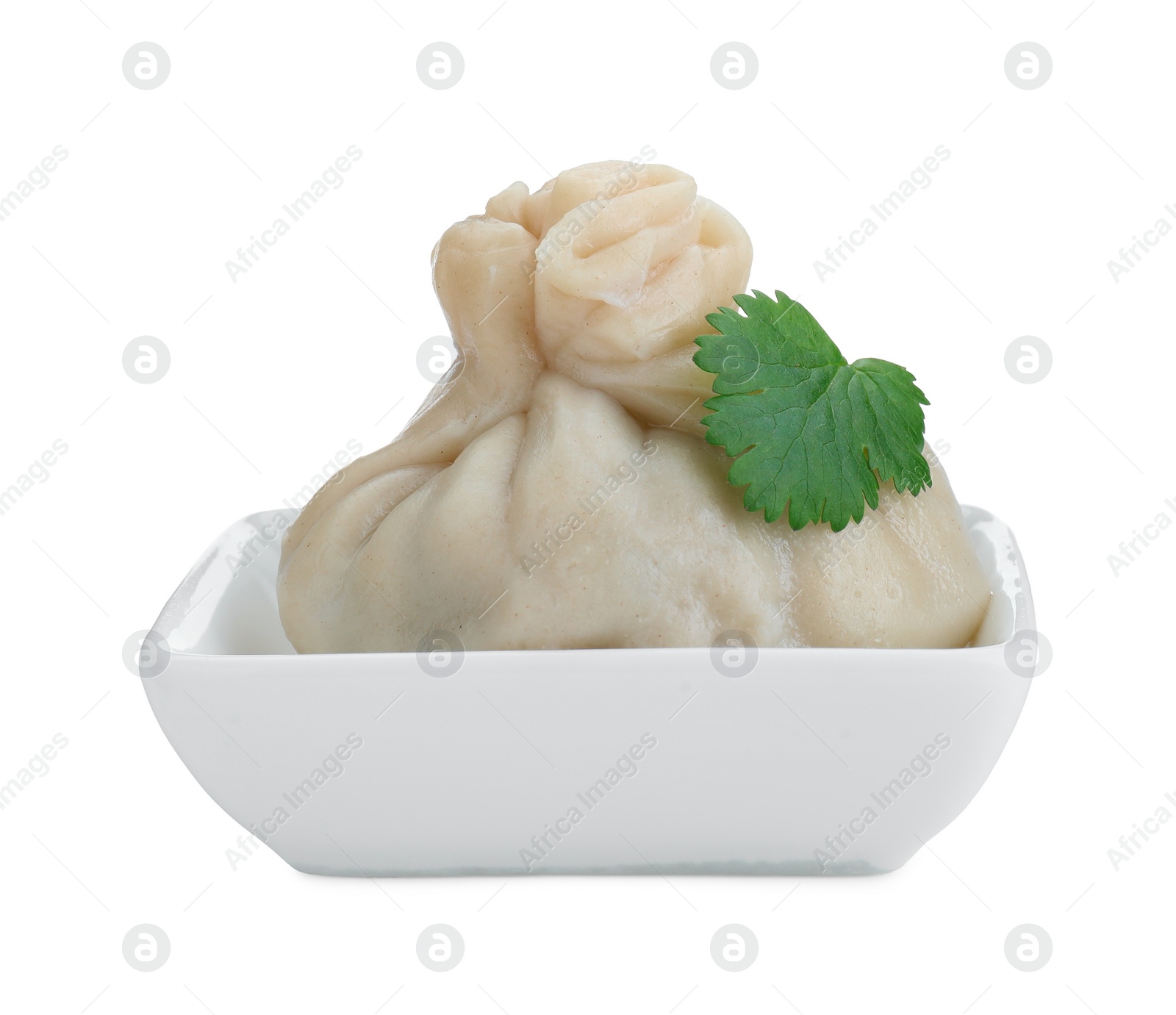 Photo of One tasty khinkali (dumpling) and parsley in bowl isolated on white. Georgian cuisine