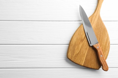 Photo of One sharp knife and board on white wooden table, top view. Space for text