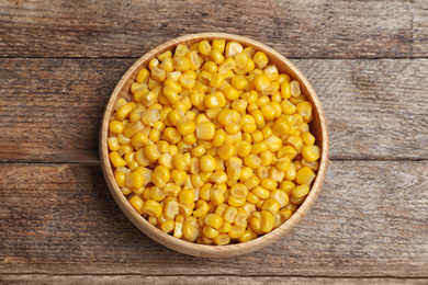 Delicious canned corn on wooden table, top view