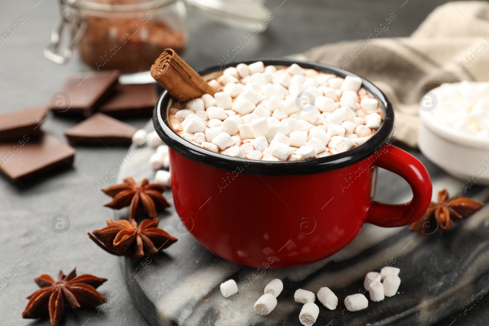 Photo of Tasty hot chocolate with marshmallows on dark textured table, closeup