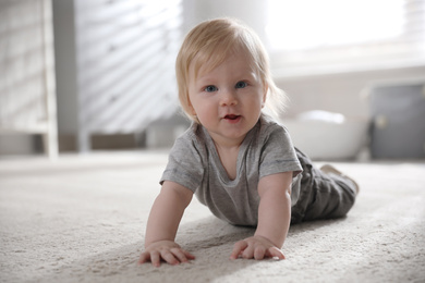 Photo of Adorable little baby on floor at home
