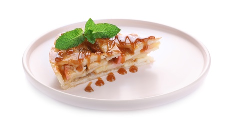 Photo of Slice of traditional apple pie with mint and syrup isolated on white