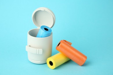 Dog waste bags and dispenser on light blue background