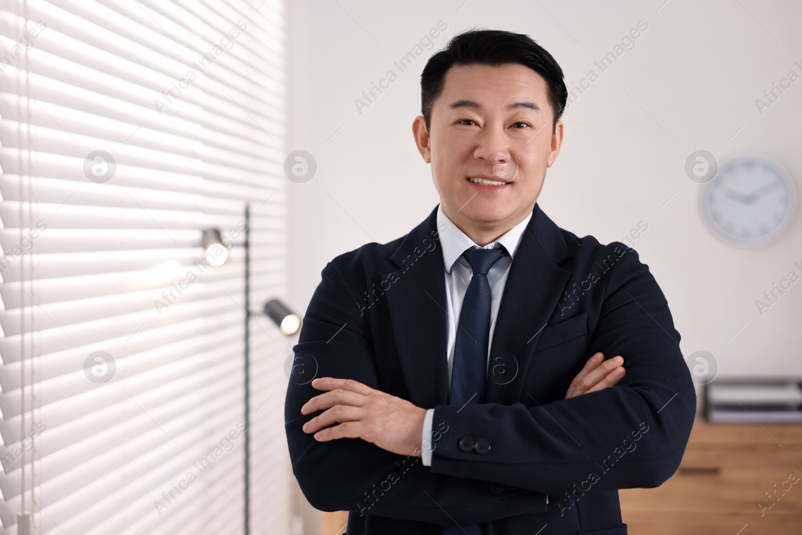 Photo of Portrait of happy notary with crossed arms in office, space for text