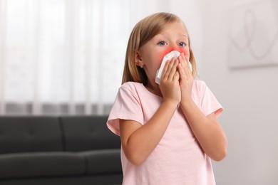 Photo of Suffering from allergy. Little girl with tissue sneezing at home, space for text