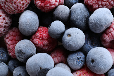 Photo of Mix of different frozen berries as background, top view