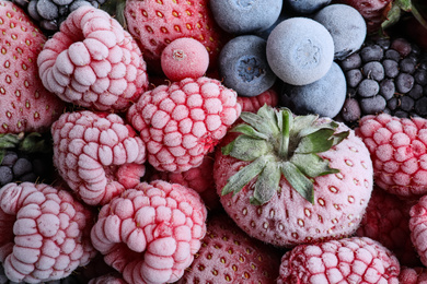 Photo of Mix of different frozen berries as background, top view