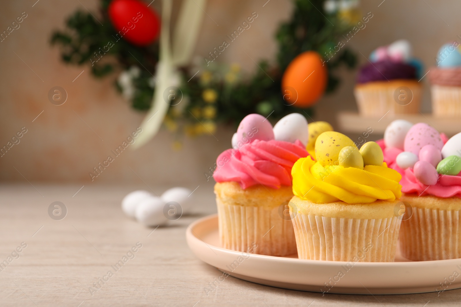 Photo of Tasty decorated Easter cupcakes on wooden table, closeup. Space for text