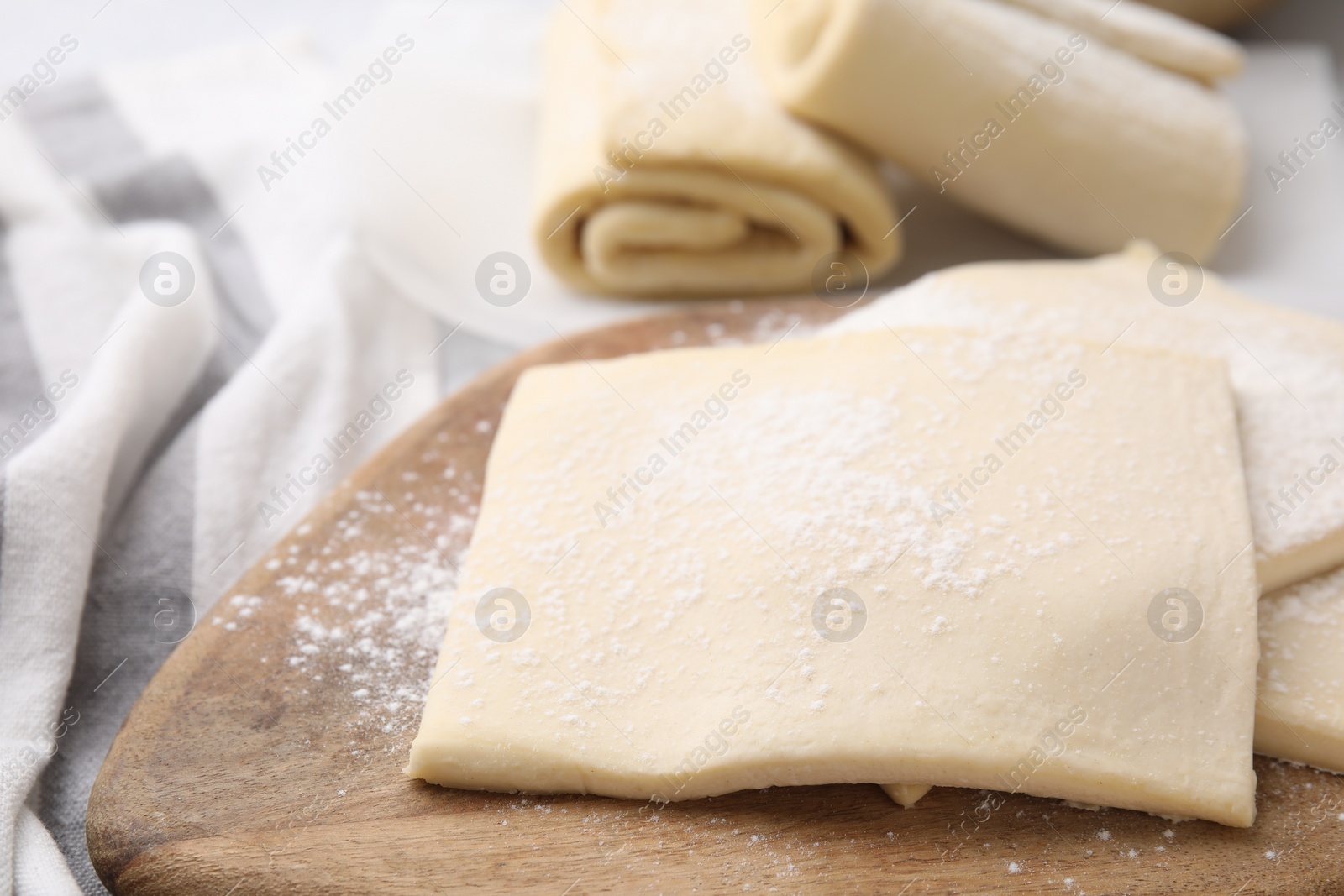 Photo of Raw puff pastry dough on table, closeup