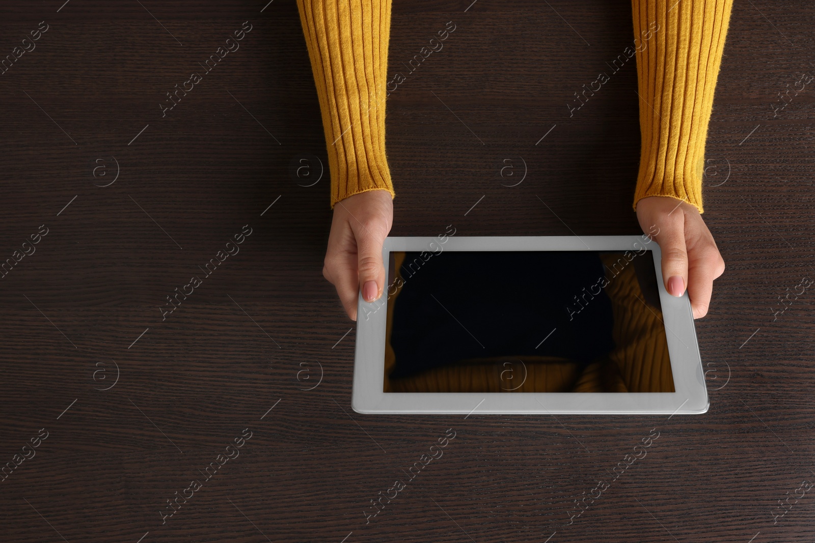 Photo of Woman working with tablet at wooden table, top view. Space for text