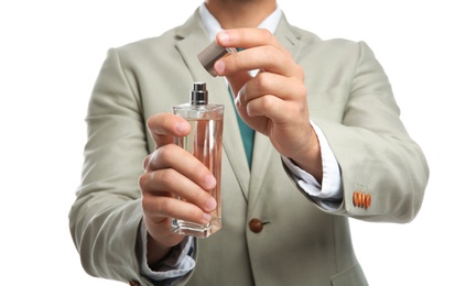 Photo of Businessman holding bottle of perfume on white background, closeup