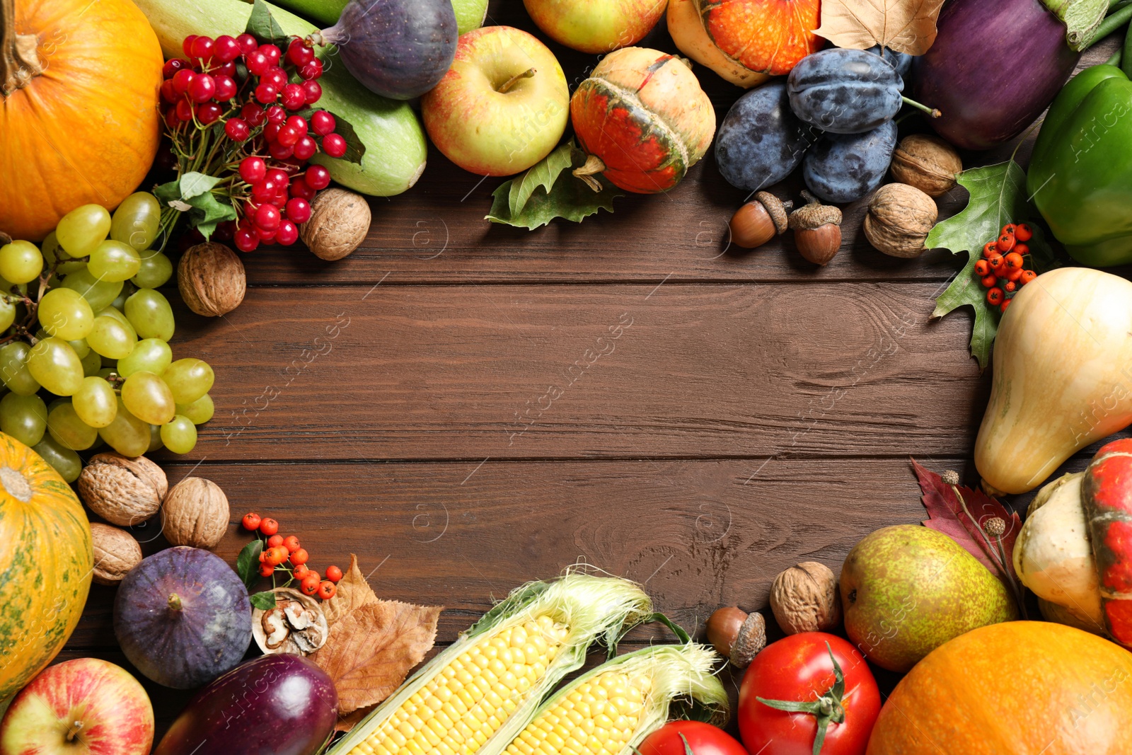 Photo of Frame made of autumn vegetables and fruits on wooden background, top view with space for text. Happy Thanksgiving day