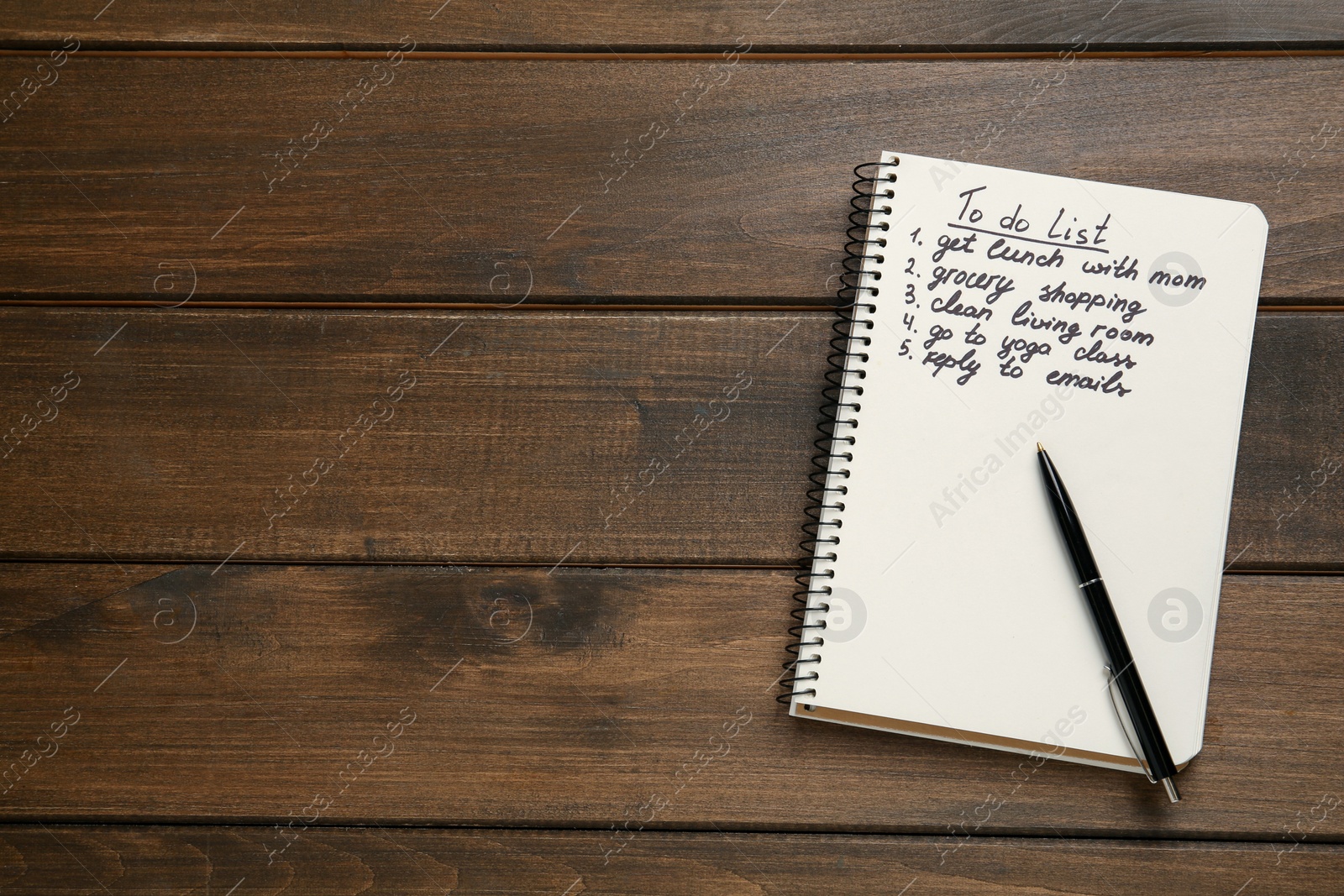 Photo of Notebook with to do list and pen on wooden table, flat lay. Space for text