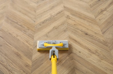 Photo of Washing of parquet floor with mop, above view