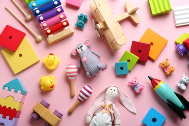 Photo of Different toys on pink background, flat lay