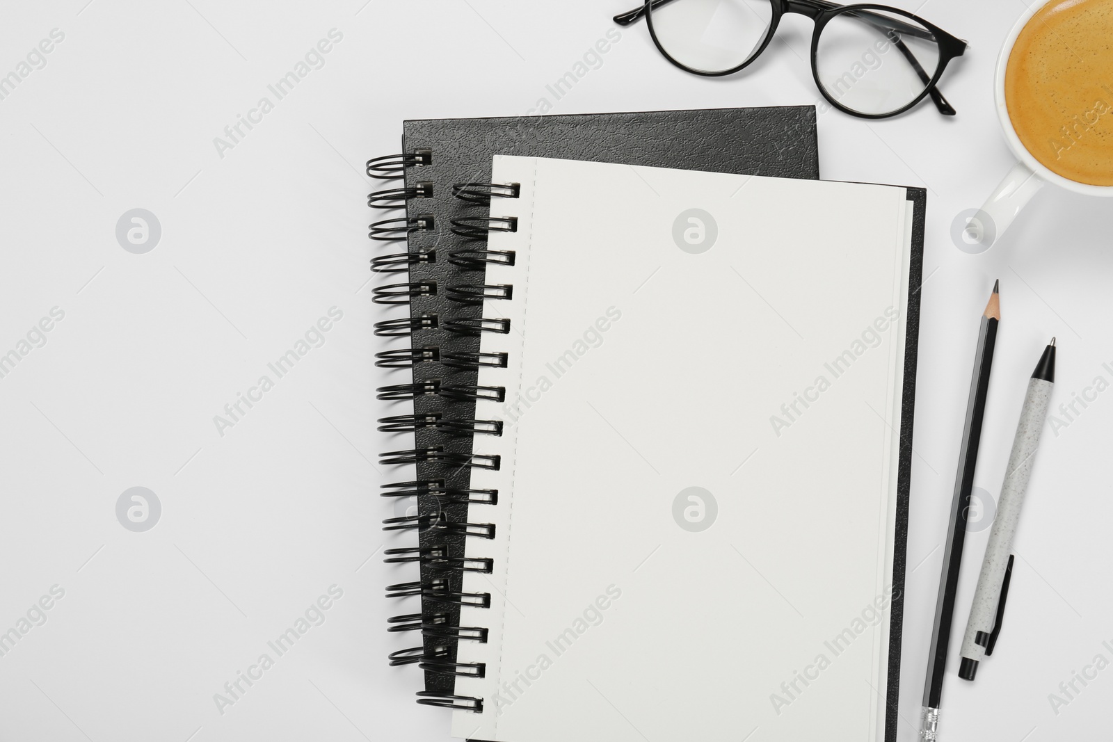 Photo of Flat lay composition with notebooks and coffee on white table