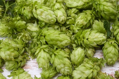 Photo of Fresh green hops on white wooden table, closeup