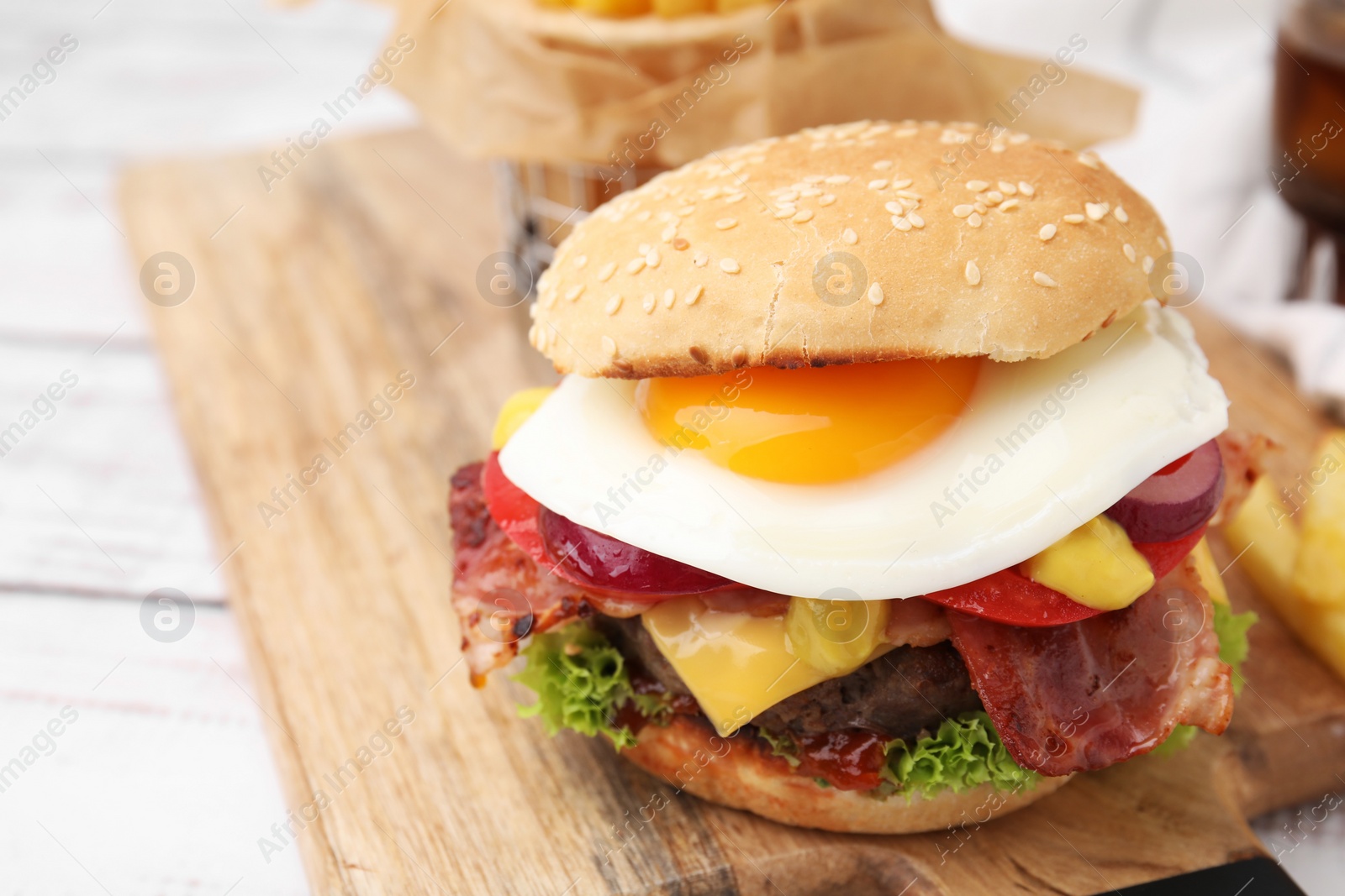 Photo of Delicious burger with fried egg on table, closeup. Space for text