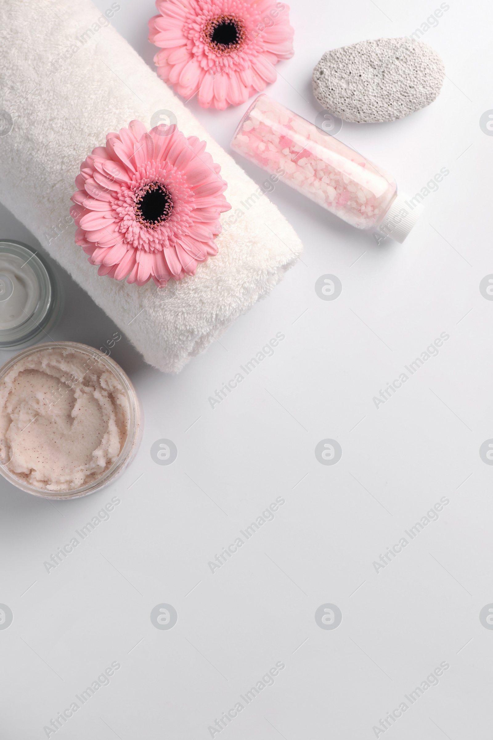 Photo of Flat lay composition with different spa products and beautiful flowers on white table. Space for text