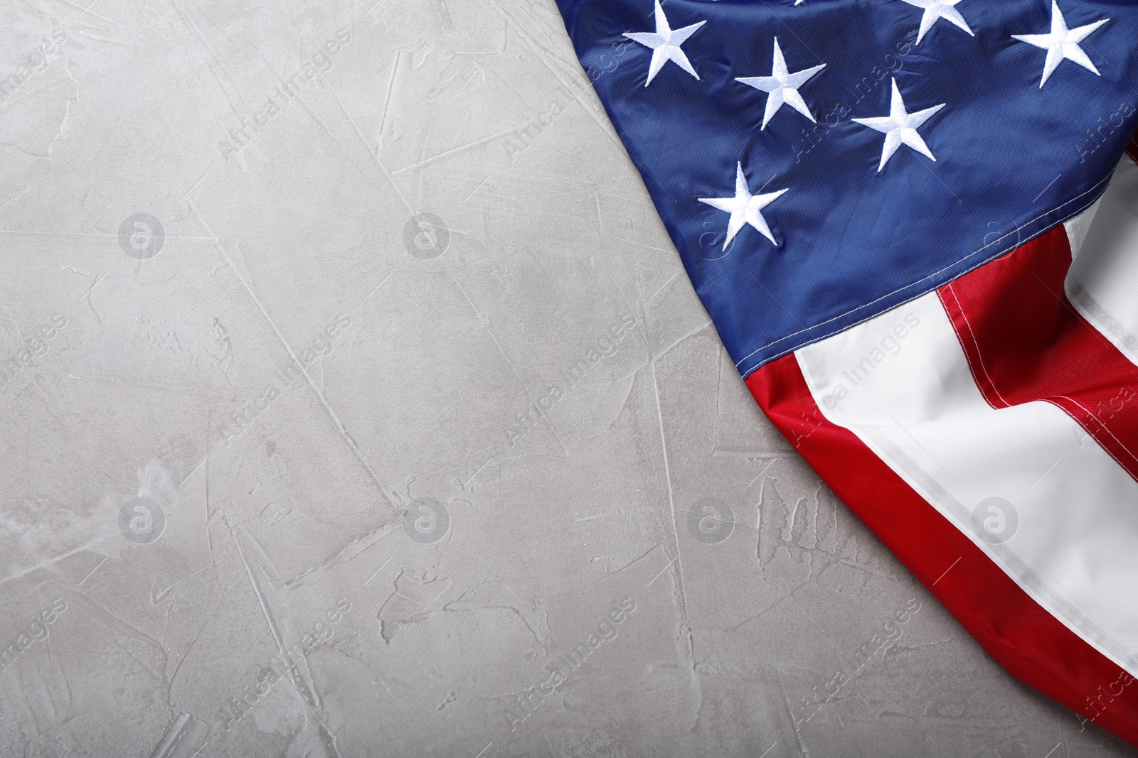 Photo of National flag of America on light grey table, top view. Space for text