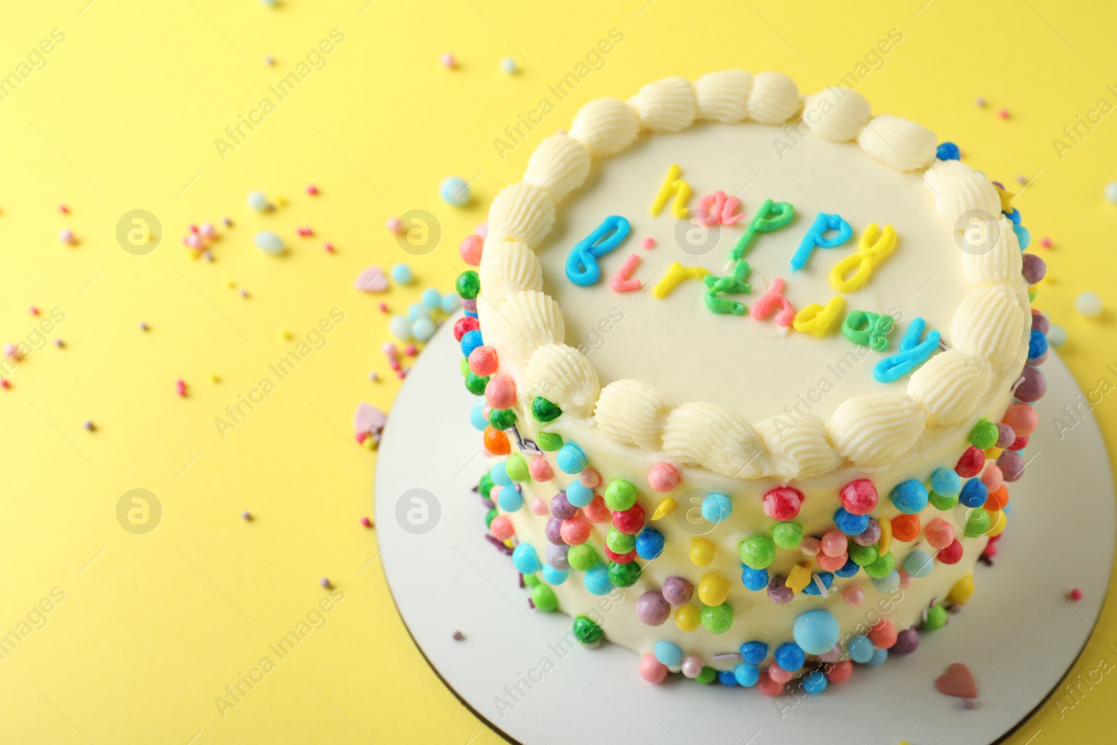 Photo of Cute bento cake with tasty cream on yellow background, space for text